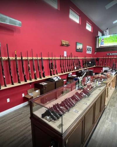 long guns leaning against red wall