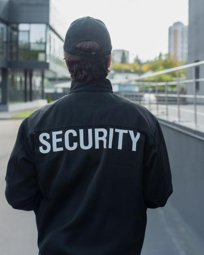 back of security officer outside, jacket says security on back