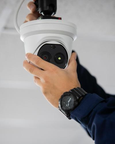 close up of hands installing security camera in house