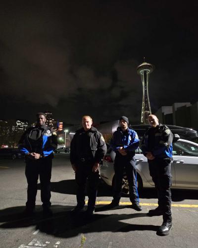 four officers in seattle space needle in background at night
